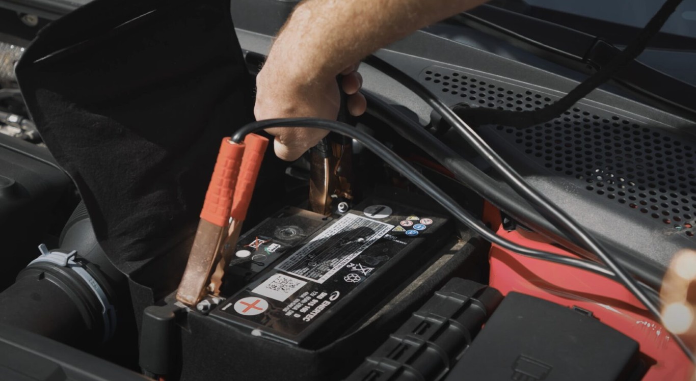 Towing professional providing battery jumpstart roadside assistance